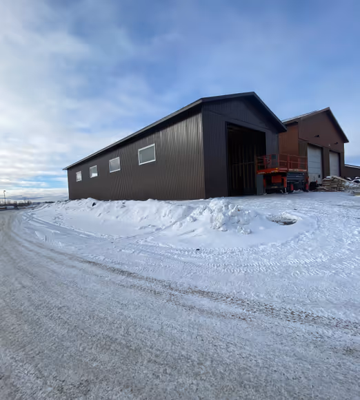 Completed dark house with light garage in snowy landscape